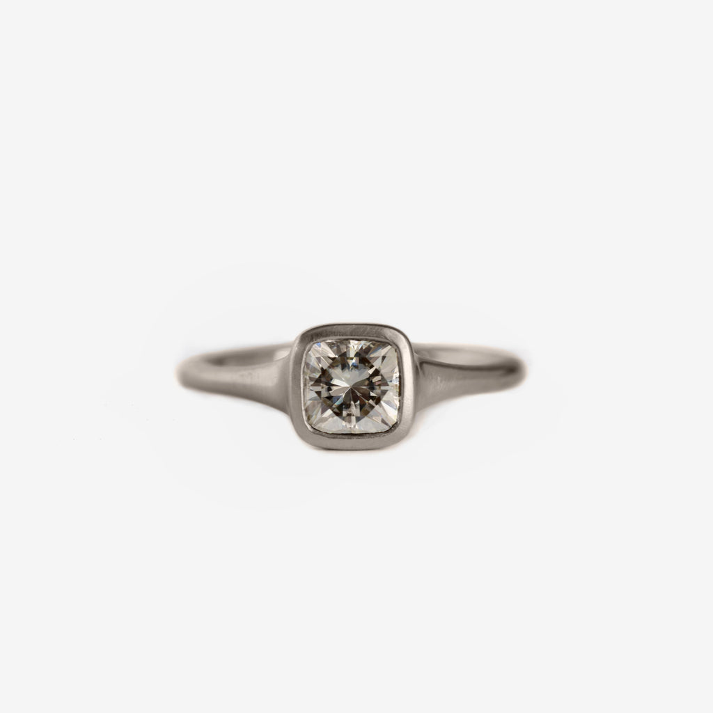 Cushion shaped diamond bezel ring in 18k palladium white gold